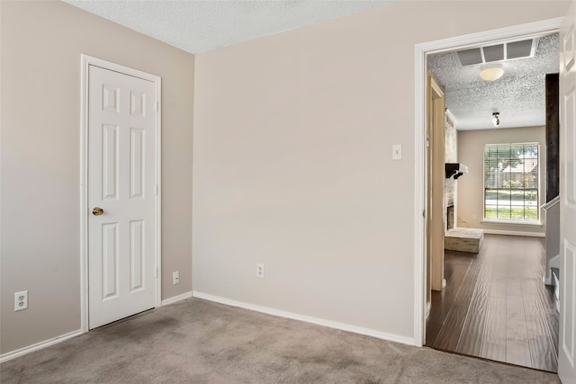 carpeted spare room featuring a textured ceiling