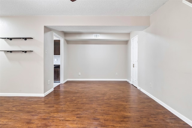 empty room with a textured ceiling and hardwood / wood-style floors