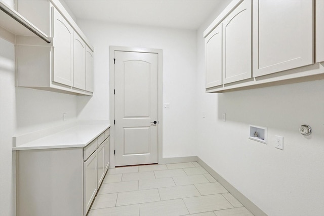 laundry area featuring hookup for a washing machine, cabinets, and light tile patterned floors