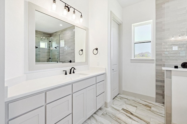 bathroom featuring a tile shower and vanity