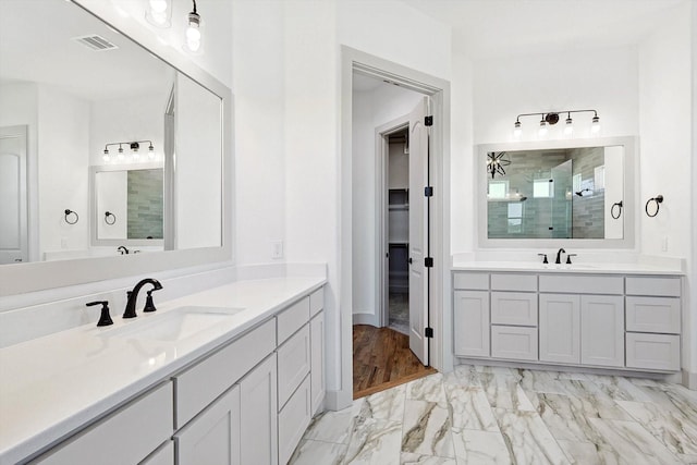 bathroom with a tile shower and vanity