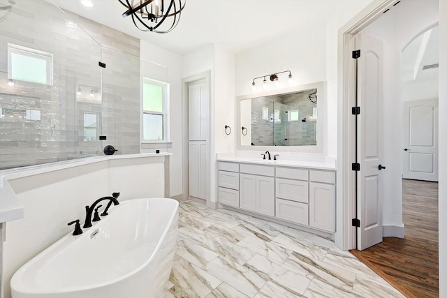 bathroom featuring independent shower and bath, hardwood / wood-style flooring, and vanity