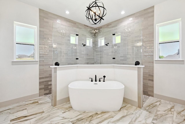 bathroom featuring separate shower and tub and a chandelier