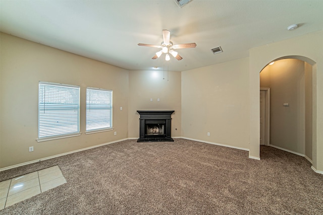 unfurnished living room with ceiling fan and carpet