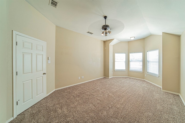 empty room with lofted ceiling, ceiling fan, and carpet floors