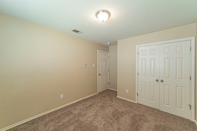 unfurnished bedroom with carpet flooring and a closet