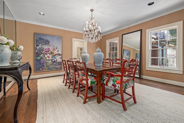 dining area with crown molding, wood-type flooring, and a chandelier