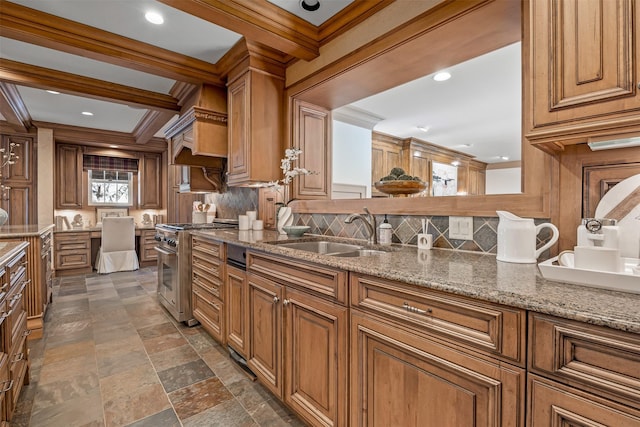 kitchen featuring stone counters, built in desk, high end stove, tasteful backsplash, and sink