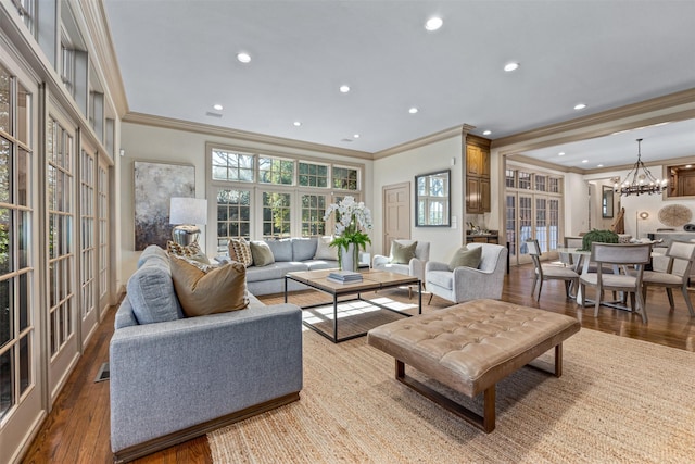 living room featuring french doors, ornamental molding, light hardwood / wood-style floors, and a notable chandelier