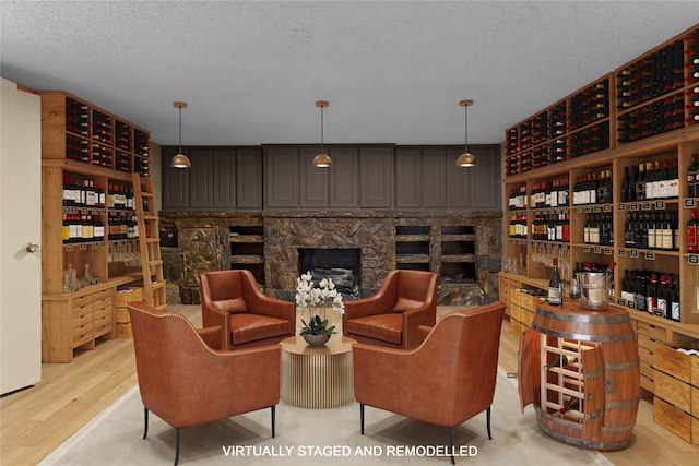 interior space featuring a textured ceiling, light hardwood / wood-style floors, and a fireplace