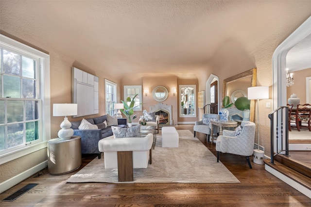 living room with dark wood-type flooring and a wealth of natural light