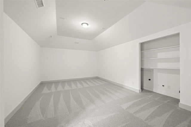 carpeted empty room featuring vaulted ceiling