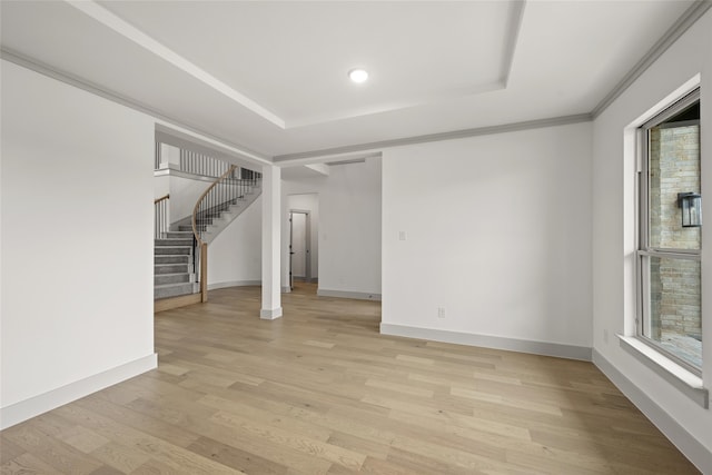 basement with light wood-type flooring, a wealth of natural light, and crown molding