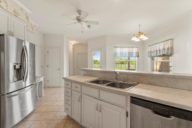 kitchen with sink, stainless steel appliances, light tile floors, and white cabinetry