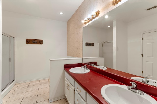 bathroom featuring a shower with shower door, tile floors, and dual vanity