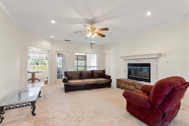 living room featuring ceiling fan, carpet flooring, a fireplace, and crown molding