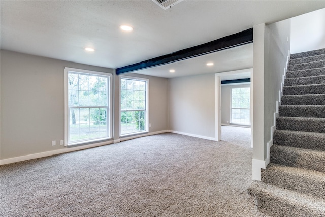 carpeted spare room with beam ceiling