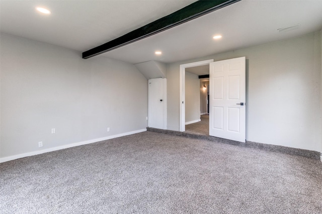 unfurnished room featuring beam ceiling and dark colored carpet