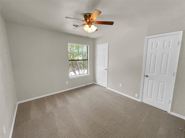 unfurnished room with ceiling fan and carpet