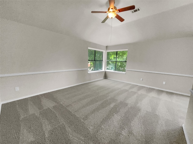 unfurnished room featuring carpet floors, a textured ceiling, vaulted ceiling, and ceiling fan