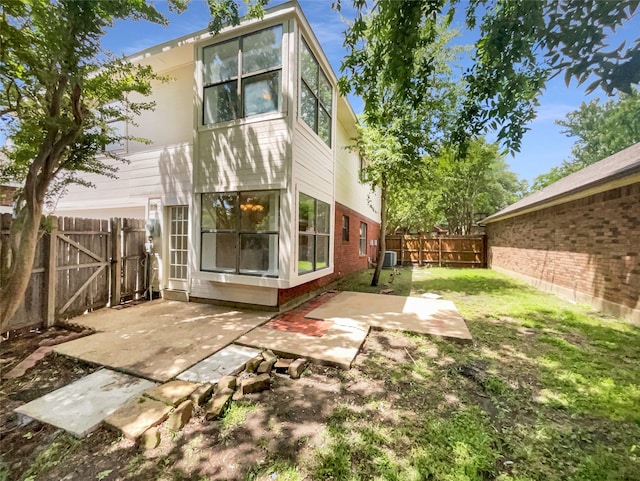 rear view of property featuring central AC unit, a patio area, and a yard