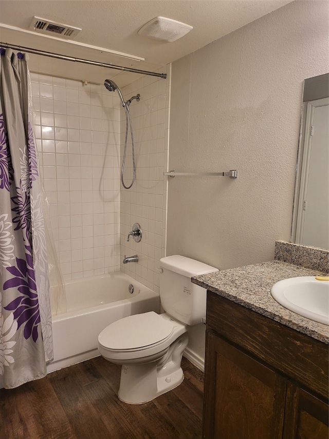 full bathroom with shower / tub combo, toilet, a textured ceiling, vanity, and hardwood / wood-style floors