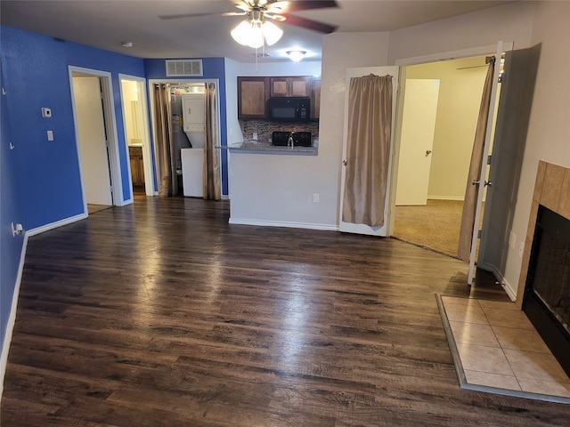 unfurnished room featuring hardwood / wood-style floors, ceiling fan, and a tiled fireplace