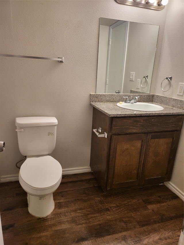 bathroom featuring large vanity, toilet, and hardwood / wood-style flooring