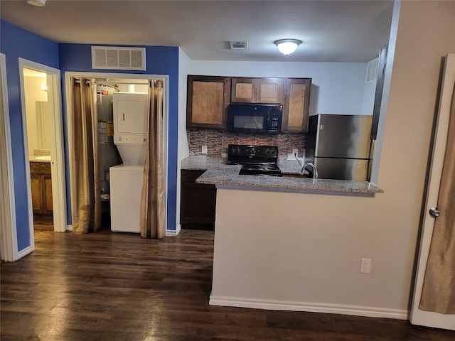 kitchen featuring sink, backsplash, stacked washer and dryer, dark hardwood / wood-style flooring, and black appliances