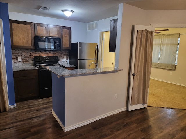 kitchen with kitchen peninsula, backsplash, black appliances, dark brown cabinetry, and dark hardwood / wood-style flooring