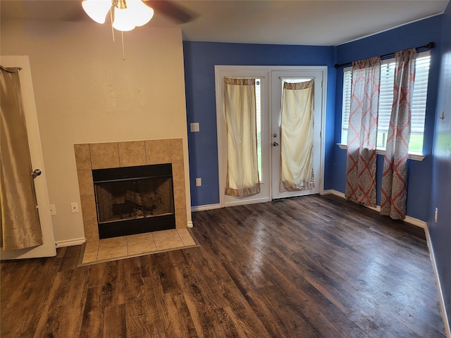 unfurnished living room with dark hardwood / wood-style flooring, ceiling fan, and a tile fireplace