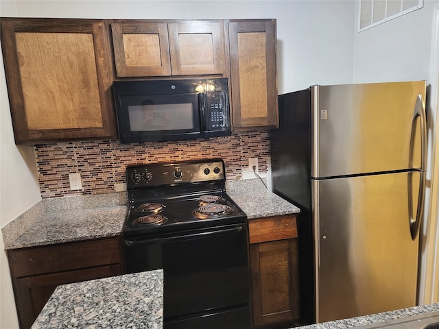 kitchen with backsplash, stone counters, and black appliances