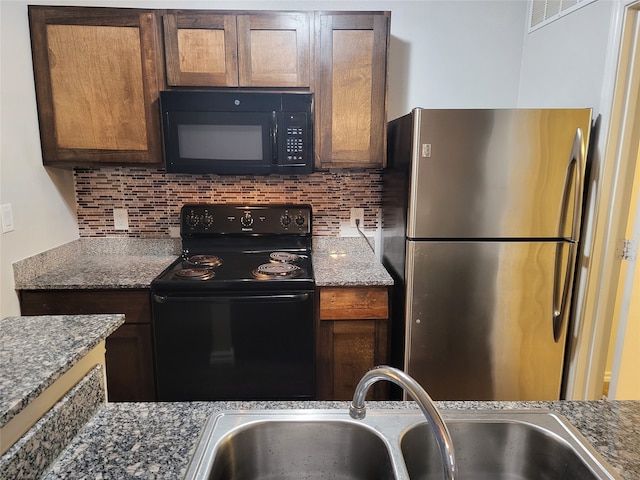 kitchen with sink, stone counters, backsplash, and black appliances