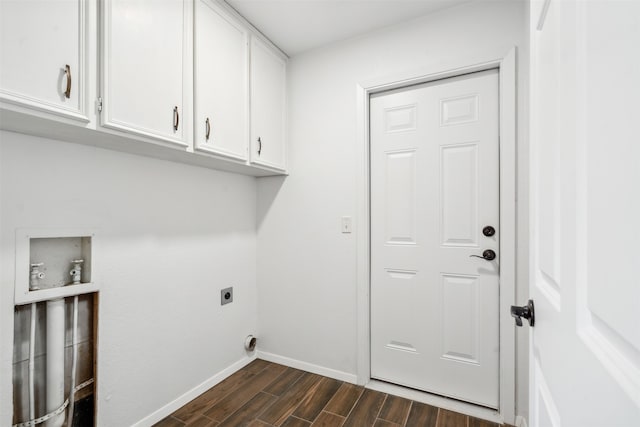 laundry room featuring electric dryer hookup, dark hardwood / wood-style flooring, and cabinets