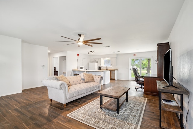 living room featuring ceiling fan and dark hardwood / wood-style floors