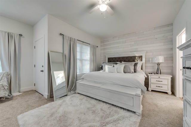 carpeted bedroom featuring ceiling fan and wood walls