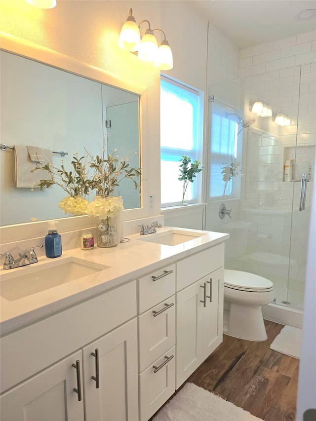 bathroom featuring walk in shower, hardwood / wood-style floors, vanity, and toilet