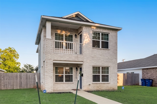 view of front facade featuring a balcony and a front lawn