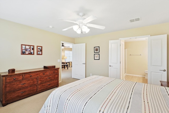 bedroom featuring ceiling fan, light carpet, and ensuite bathroom