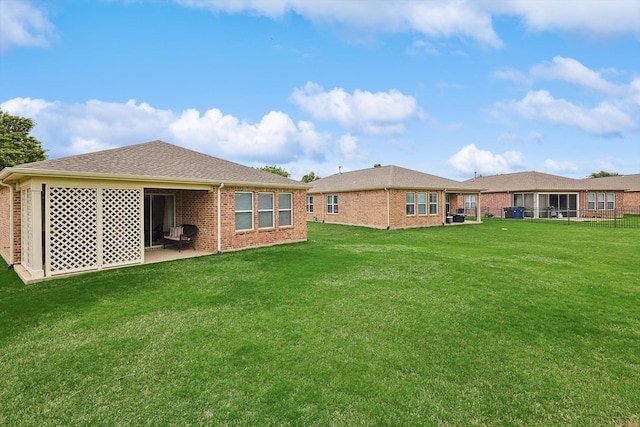 back of house with a patio and a yard