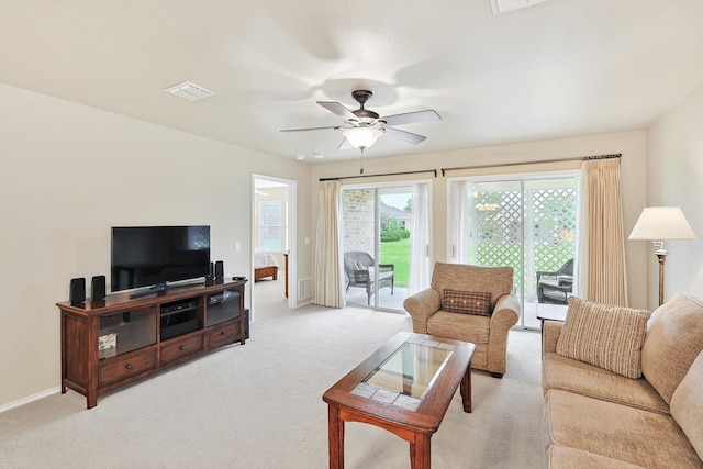 carpeted living room with ceiling fan