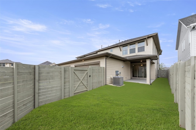 rear view of property featuring central AC, a patio area, and a yard