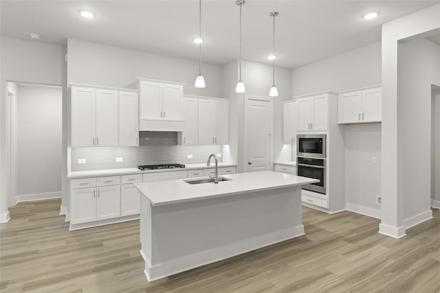 kitchen with stainless steel appliances, white cabinets, and light hardwood / wood-style floors