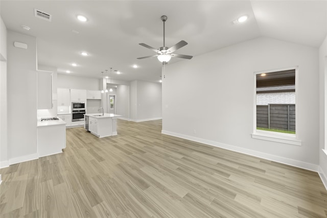 unfurnished living room featuring ceiling fan, light hardwood / wood-style flooring, lofted ceiling, and sink