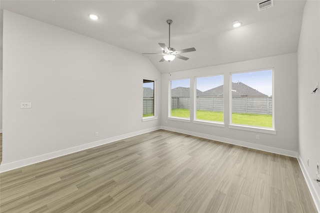 spare room with a wealth of natural light, light hardwood / wood-style floors, and lofted ceiling