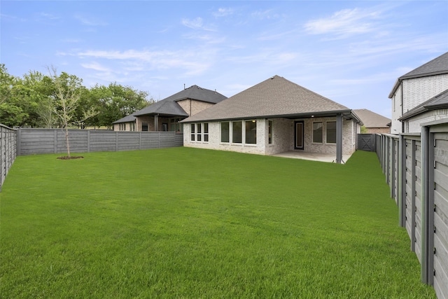 rear view of property with a yard and a patio