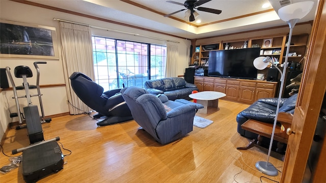 living room with ornamental molding, light hardwood / wood-style flooring, and ceiling fan