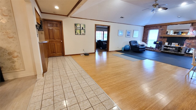 workout room featuring light hardwood / wood-style flooring, ceiling fan, crown molding, brick wall, and lofted ceiling