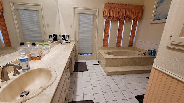 bathroom with a bath, dual vanity, and tile floors