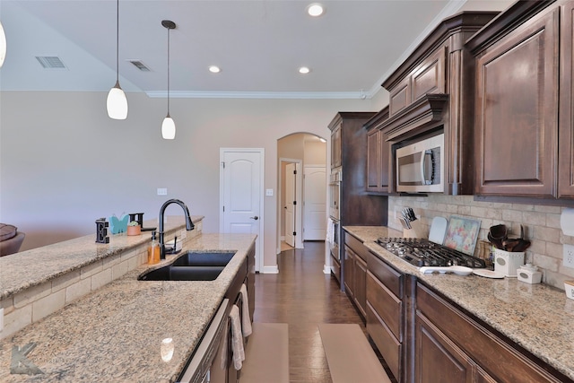 kitchen with decorative light fixtures, dark wood-type flooring, backsplash, appliances with stainless steel finishes, and sink